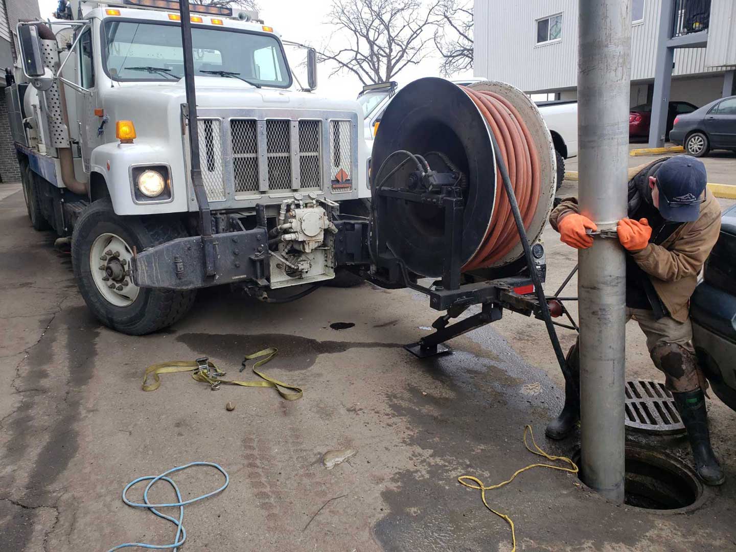 Hydrovac truck with worker cleaning manhole