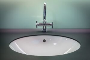 chrome-bathroom-sink-against-teal-wall