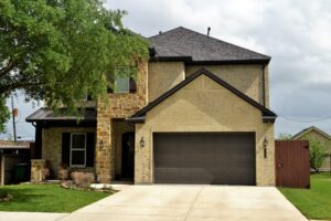 Modern-yellow-brick-home-with-tree-in-front-yard