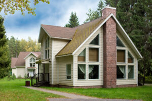 house-with-large-windows-and-brown-roof-on-green-lawn